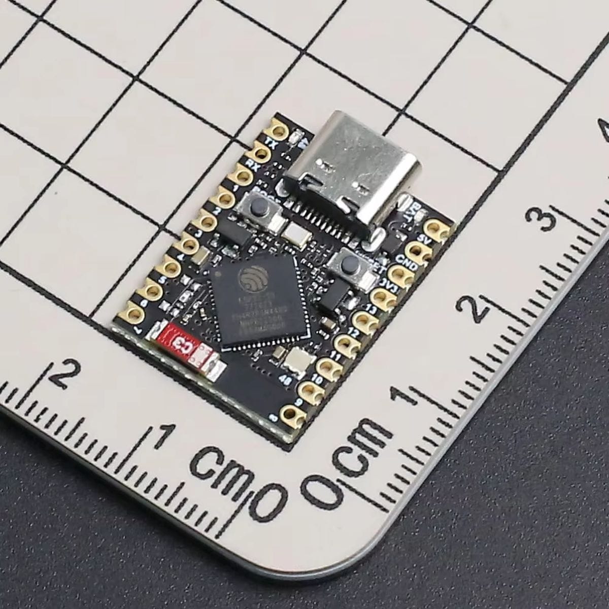 ESP32-S3 SuperMini mikrokontrolleres panel fehér háttéren, USB-C aljzattal, aranyozott peremfuratokkal és Espressif chippel, kompakt IoT vezérléshez.