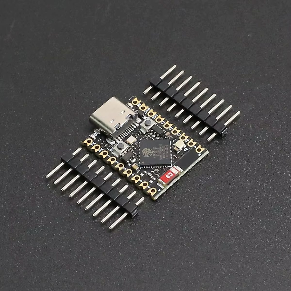 Kisméretű fekete ESP32-S3 fejlesztőpanel USB-C csatlakozóval, nyomógombokkal és sűrű SMD alkatrészekkel, vezeték nélküli mikrokontrolleres projektekhez.
