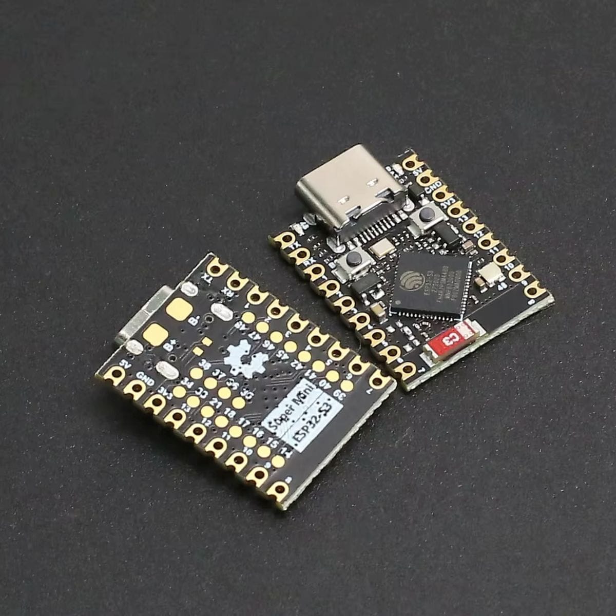 Fekete ESP32-S3 SuperMini fejlesztőpanel közeli nézetben, USB-C csatlakozóval, Espressif chippel, aranyozott forrasztási pontokkal és nyomógombokkal, mikrokontrolleres vezérléshez és IoT prototípushoz, kompakt beépítésű projektekben jól használható kialakítással.