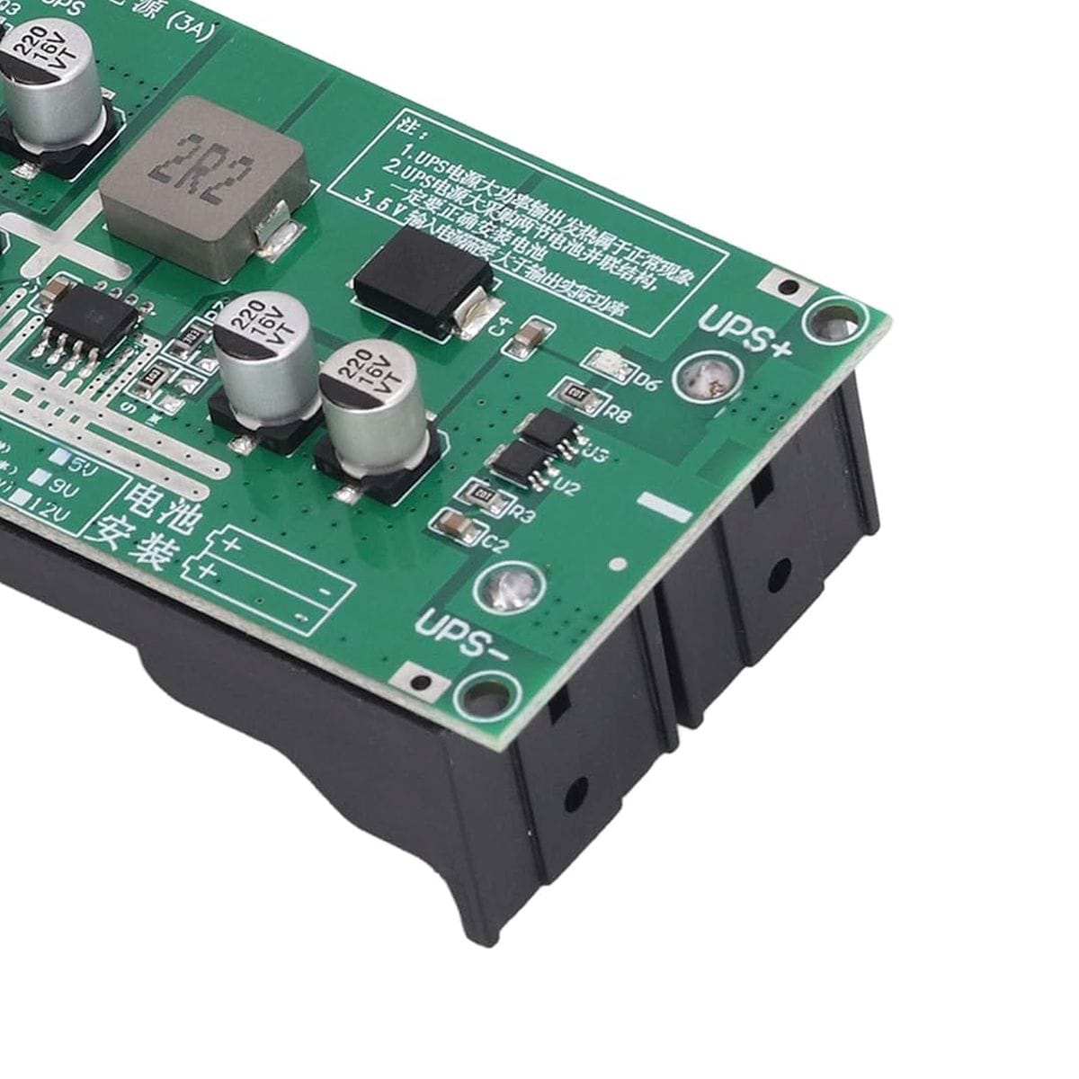 Az LX2-BUPS-12V modul zöld áramköri lapja fekete, kétcellás 18650 tartó fölött látható, USB-C csatlakozóval, tekercsekkel és 12 voltos tartalék tápellátáshoz kialakított bekötési pontokkal kisfogyasztású elektronikai eszközök számára.