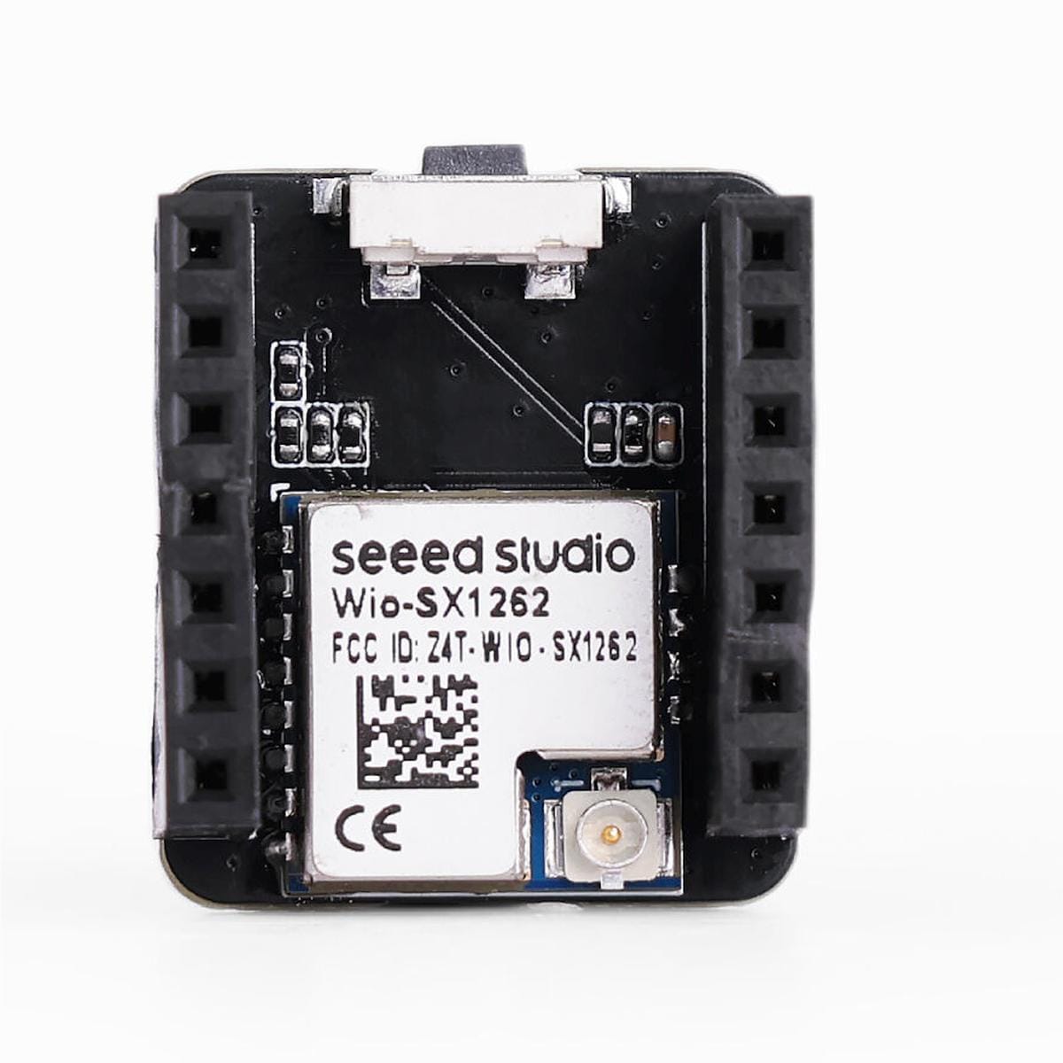 Seeed Studio Wio-SX1262 rádiós modul szemből, kétoldali fekete foglalatsorral, középen árnyékolt SX1262 egységgel, alul kis antennacsatlakozóval és felül kapcsolóval.
