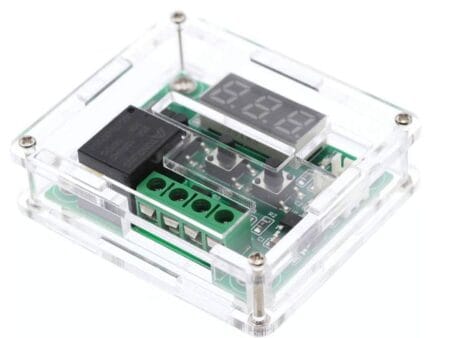 Egy átlátszó akril/plexi ház egy W1209 digitális termosztát modulhoz, amelyben jól látható az előlap‑nyílás és a rögzítő csavarok — elektronikai DIY környezetben.