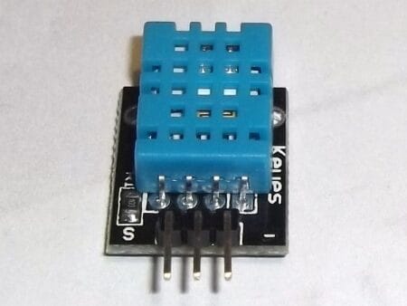 Egy DHT11 digitális hőmérséklet- és páratartalom-érzékelő modul közelről, háromlábú csatlakozóval, mikrokontrolleres projektekhez, Arduino-kompatibilitással.