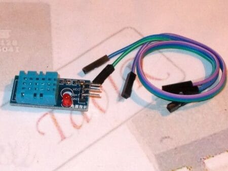 Egy DHT11 digitális hőmérséklet- és páratartalom-érzékelő modul közelről, háromlábú csatlakozóval, mikrokontrolleres projektekhez, Arduino-kompatibilitással.