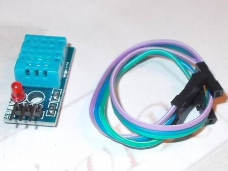 Egy DHT11 digitális hőmérséklet- és páratartalom-érzékelő modul közelről, háromlábú csatlakozóval, mikrokontrolleres projektekhez, Arduino-kompatibilitással.