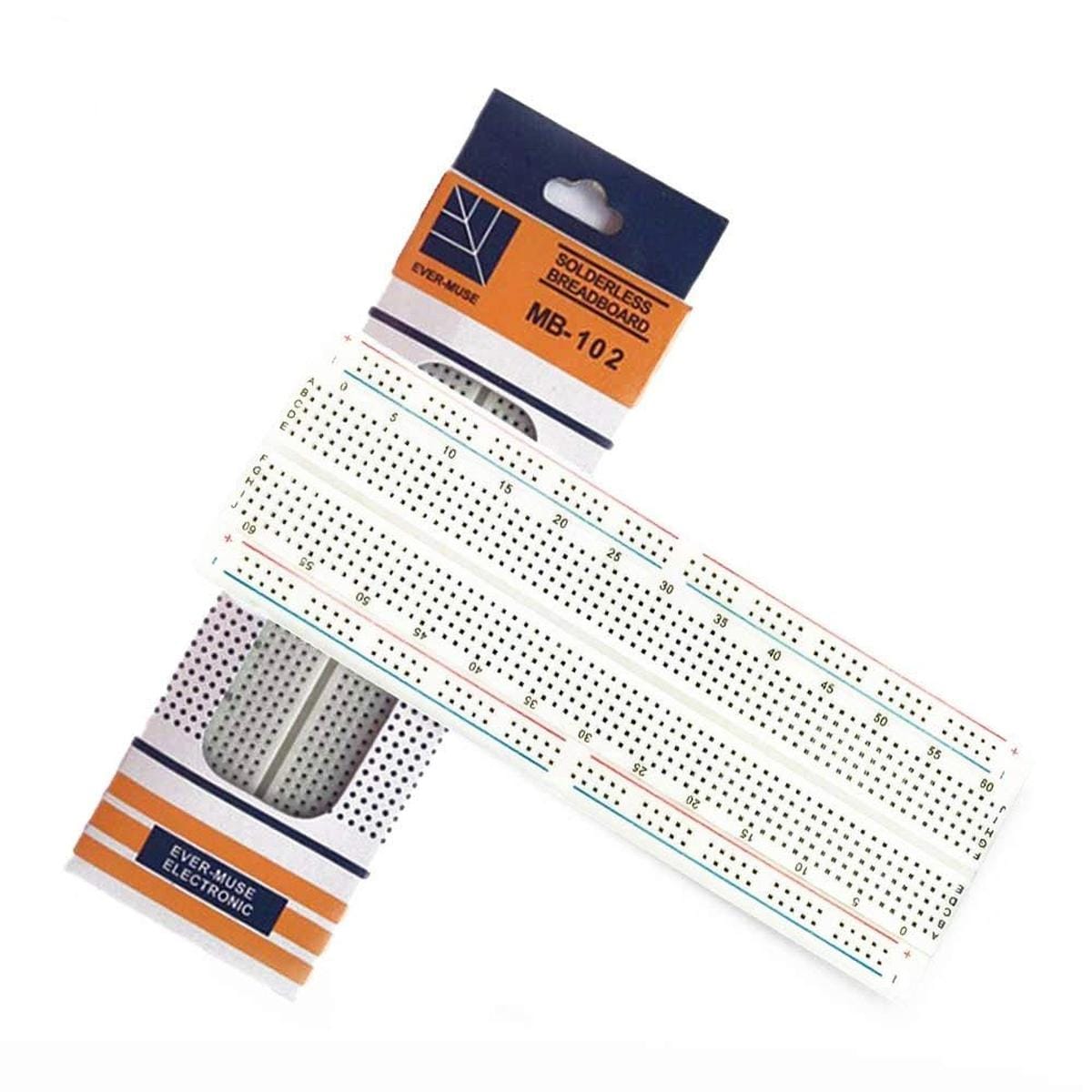 MB-102 jelölésű forrasztásmentes breadboard részben kihúzva narancs-fehér gyári csomagolásából, jól látható számozott érintkezőmezőkkel és hosszanti piros-kék tápvonalakkal.