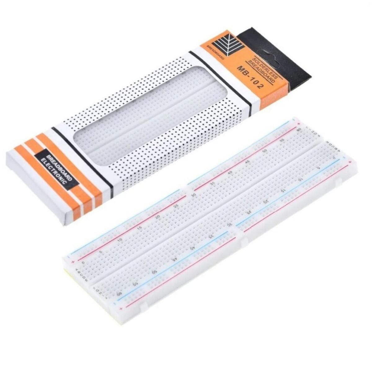 MB-102 jelölésű 830 lyukas breadboard gyári kartoncsomagolás mellett, fehér próbapanellel, számozott sorokkal és piros-kék tápvonalakkal forrasztásmentes elektronikai kísérletekhez.